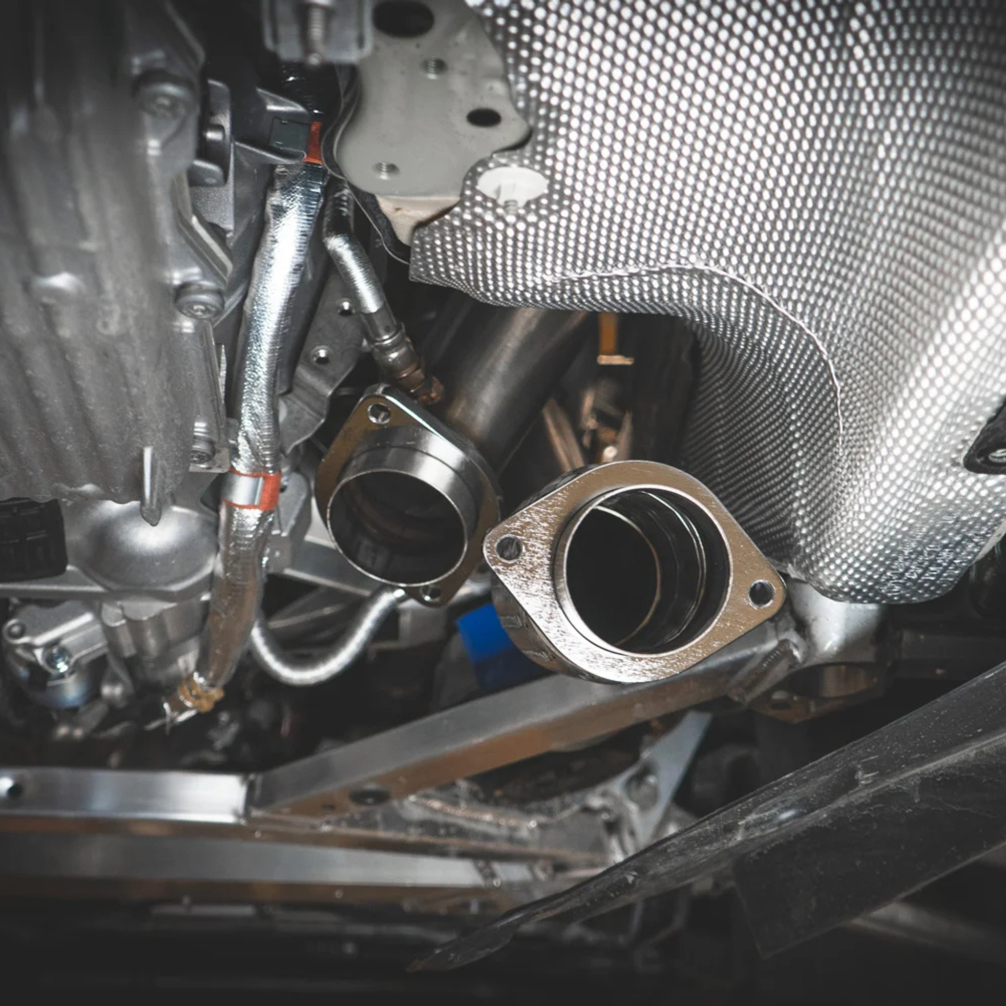 Performance downpipe with heat shield installed in BMW S58 engine - downpipe installation service for M2, M3, M4 at Bimmer Tech in Los Angeles and Orange County