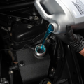 Blue coolant being poured into BMW engine during cooling system flush and refill service at Bimmer Tech in Los Angeles and Orange County